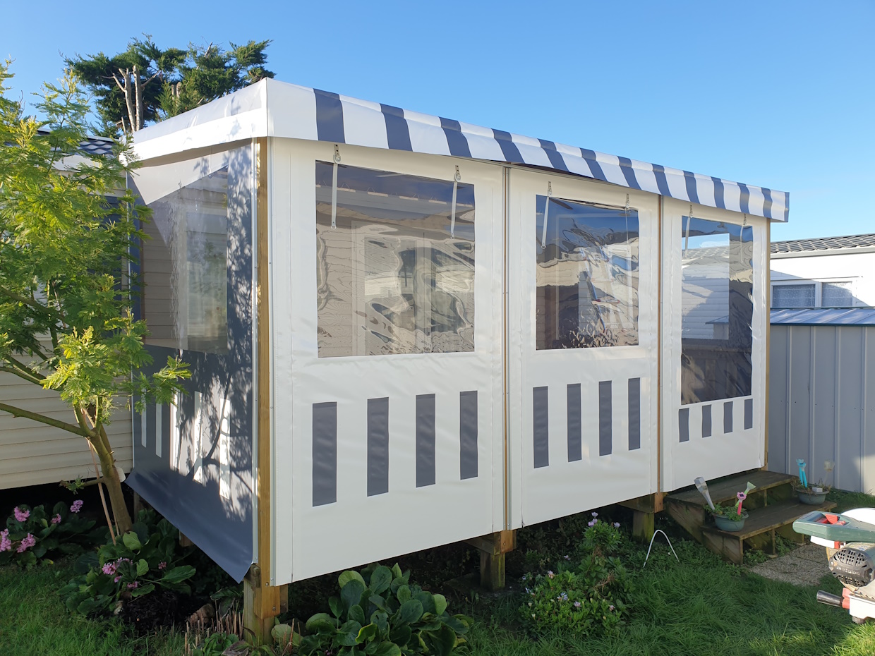 Véranda extérieure avec fenêtres transparentes, jardin.
