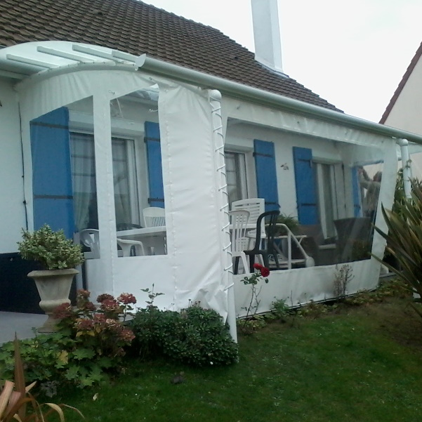 Véranda blanche avec mobilier extérieur.