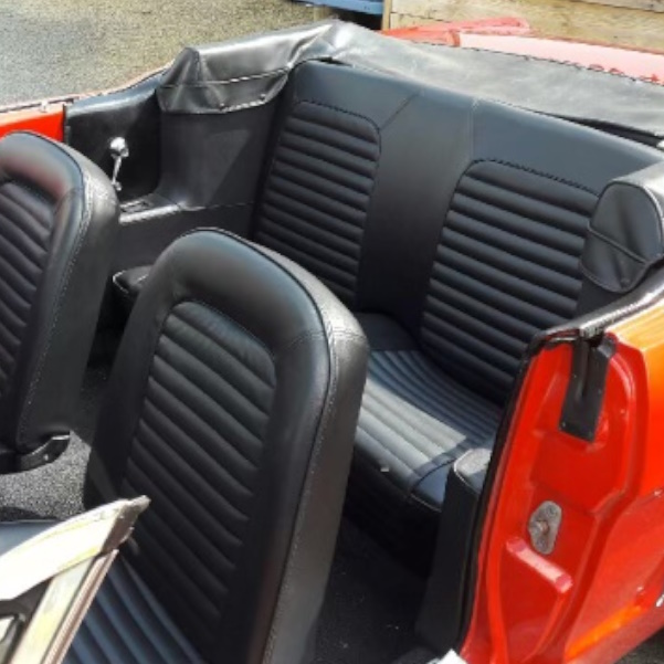 Intérieur d'une voiture vintage avec sièges en cuir noir.