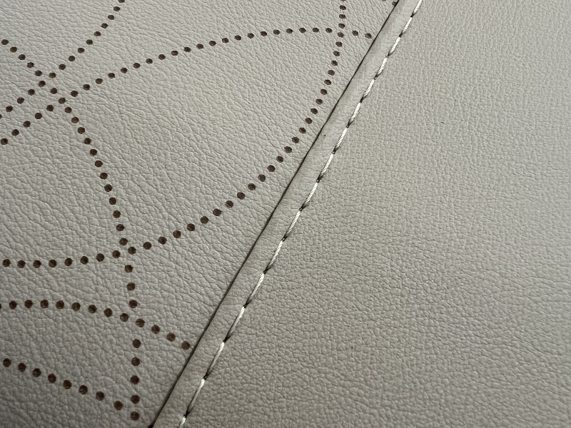 Cuir beige avec motifs et coutures visibles.
